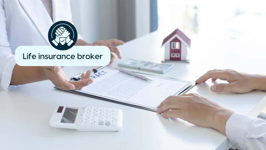 Insurance broker discussing policies with client at desk.