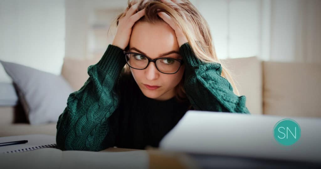 Worried woman with glasses looking at documents about life insurance.